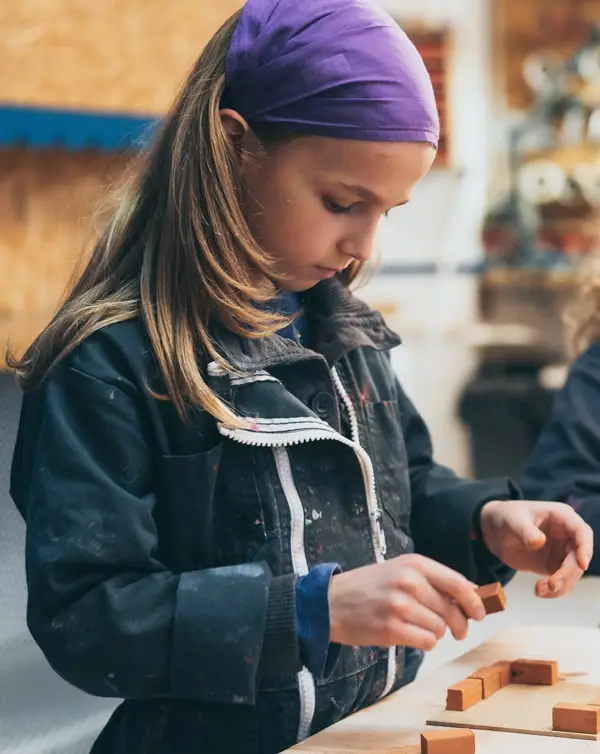 Un enfant utilise des briques pour créer une construction en briques
