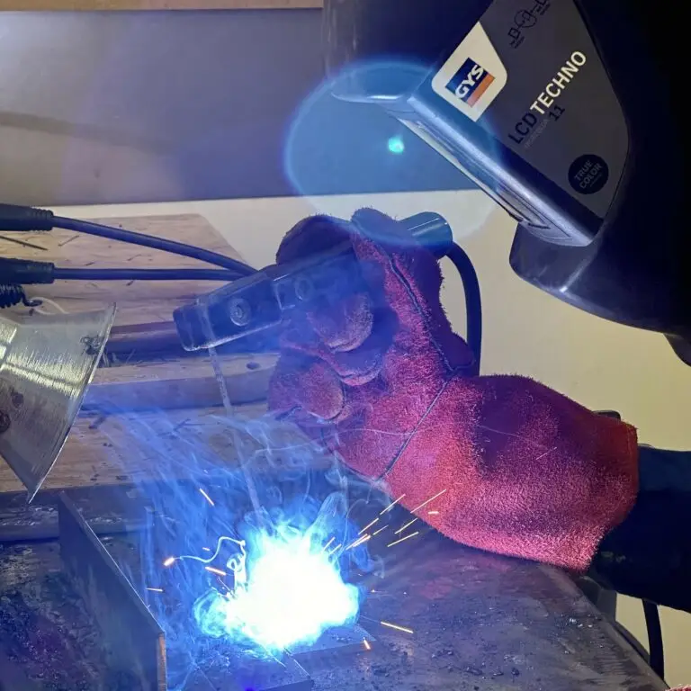 Une personne travaille dans un atelier de soudage, étincelles et fumée