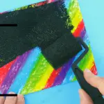 Peinture à gratter, un enfant passe de la peinture noire au rouleau
